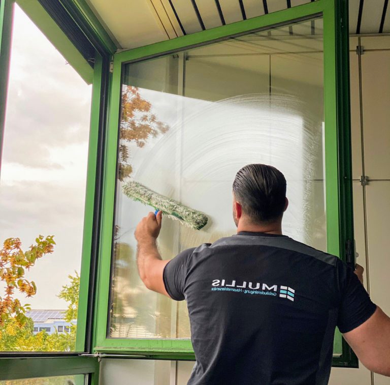 Ein Mitglied des Mullis-Teams putzt das Fenster.